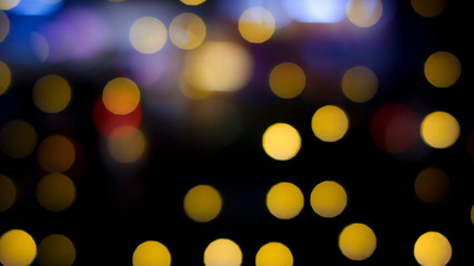 Abstract blurred multicolored hanging decorative lights with bokeh in night city background
