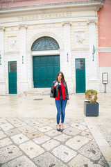 Fototapeta na wymiar Bella ragazza italiana in jeans giacca nera di pelle e camicia rossa in puglia tra le vie del centro storico di Bisceglie