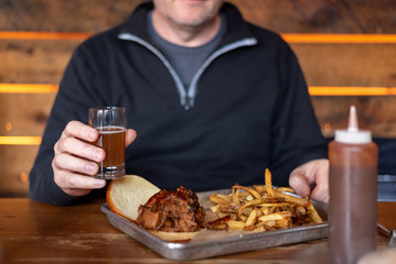 Man enjoying a beer and a sandwich at a restaurant