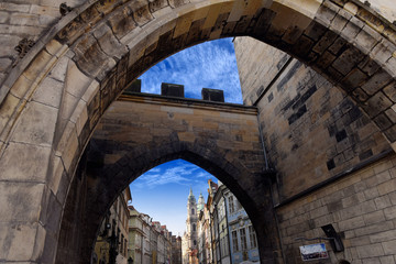 view to St. Nicholas church from Mala Strana through the arch of the Malostransky tower on Charles Bridge, Prague, Czech Republic