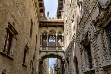 Pont del Bisbe - A sunny afternoon view of a neo-Gothic style stone bridge, "Pont del Bisbe" - Bishop's Bridge, above an old narrow alleyway in Gothic Quarter of Barcelona, Catalonia, Spain.