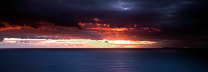 Inspirational, beautiful and striking sunset over the sea - in long and thin panorama for banners and headers.