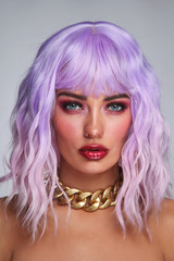 Potrait of young beautiful tanned woman with lilac hair and bright fancy makeup