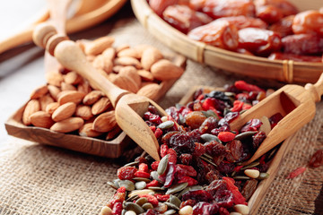 Dried fruits, various nuts and seeds on a wooden table.