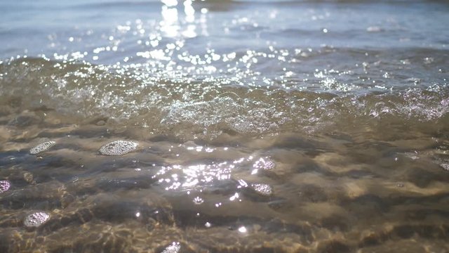 Close up beach wave on beach with pebbles stones. Soft focus