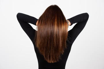 Rear view of healthy brunette smooth hair with highlights. Hair care concept with white background for copy