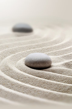 zen garden meditation stone background with stones and lines in sand for relaxation.