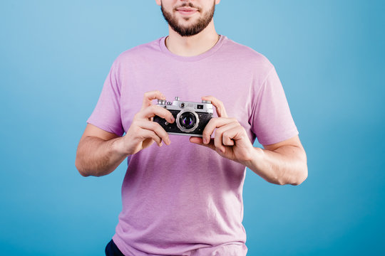 handsome man with vintage photo camera isolated on blue background