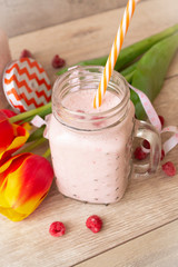 Raspberry smoothie on wooden table, vertical image