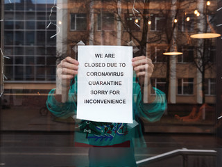 Biohazard concept of living in a new reality of coronavirus epidemy hysteria café owner sticks advertisement on quarantine measures to contain virus