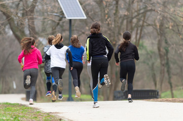 Group of happy teenage friends or sportsmen running marathon