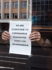 Biohazard concept of living in a new reality of coronavirus epidemy hysteria caf&eacute; owner sticks advertisement on quarantine measures to contain virus