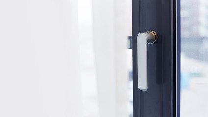 Aluminium window frame with metal handle. Copy space on a curtain for text