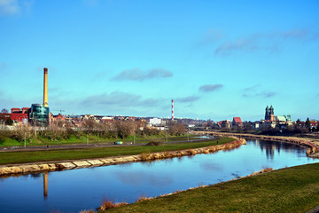 warta river, industrial chimneys and cathedral towers  in city of Poznan.