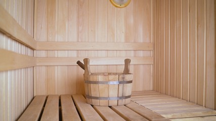 Interior details Finnish sauna steam room with traditional sauna accessories basin scoop. Traditional old Russian bathhouse SPA Concept. Relax country village bath concept. Wooden basin in the sauna