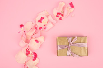 Flat lay composition with beautiful flowers and gift box on pink background. Space for text