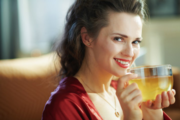 smiling woman with cup of tea at modern home in sunny day