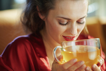 woman with cup of green tea in modern living room in sunny day