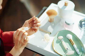 Obraz na płótnie Canvas woman applying nail polish at home in sunny day
