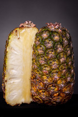 Sliced green and yellow tropical pineapple fruit without crown with the inside and outside both...