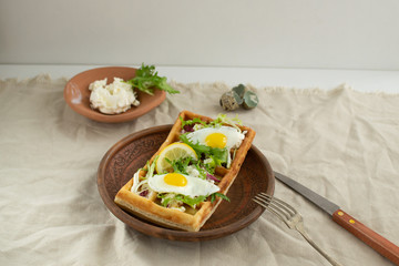 Belgian waffles with boiled quail eggs, mix of green leaves and cheese.