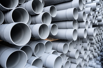 Gray PVC tubes plastic pipes stacked in rows - obrazy, fototapety, plakaty