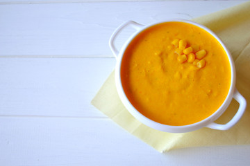 Corn soup with parsley and bread on a white background