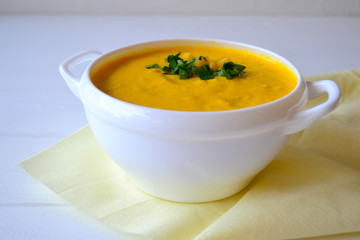 Corn soup with parsley and bread on a white background