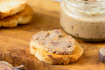 Sandwiches with homemade chicken liver pate  on a cutting board.