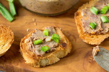 Sandwiches with homemade chicken liver pate  on a cutting board.