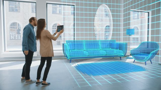 In Empty New Apartment: Lovely Young Couple Use Digital Tablet with AR Software to Choose 3D Furniture for their Cozy New Home. Happy Young People Using Technology to Design Decorate their House