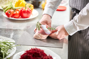 Ribs lamb ready for marinade with rosemary. Cooking with fire in frying pan. Professional chef in a kitchen of restaurant cooking.