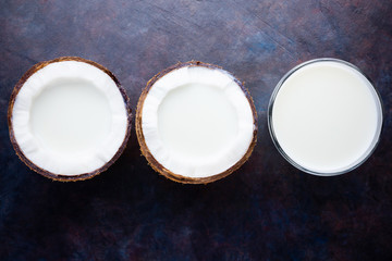 Coconut milk and coconut in glass on dark background. Coconut vegan milk non dairy with copy space. Healthy drink concept. Alternative milk. Flat lay