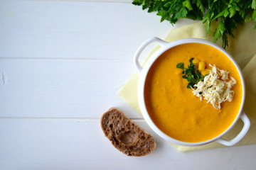 Corn soup with parsley and bread on a white background