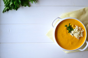Corn soup with parsley and bread on a white background