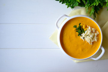 Corn soup with parsley and bread on a white background