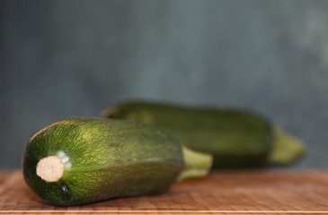 One green zucchini  on the background of another