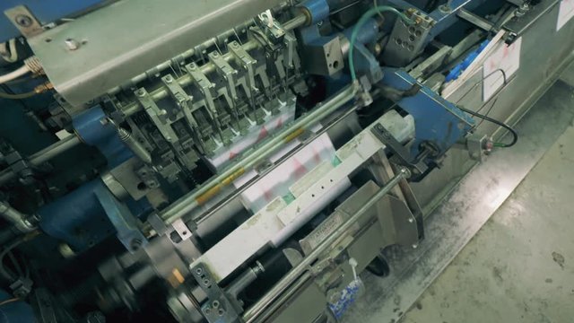 Industrial machine in binding paper with white threads