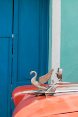 Fototapeta na wymiar Vintage flying bird hood ornament on a classic red car in Cuba