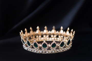 Vintage royal crown, jewellery with emeralds. Concept of power and wealth