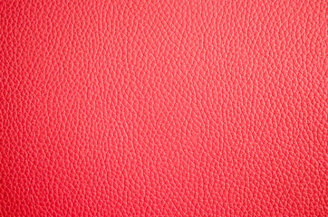 Leather texture close up. Pink fashionable background, top view. Stylish wallpaper of coral color. Rough surface.