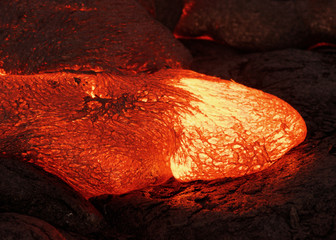 Details of an active lava flow, hot magma emerges from a crack in the earth