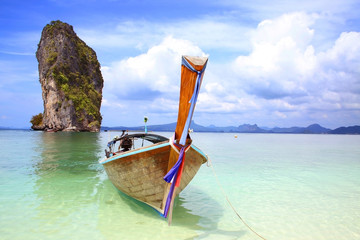 One Thai fishing boat tied up on the beach with a beautiful island in the background, Krabi,...