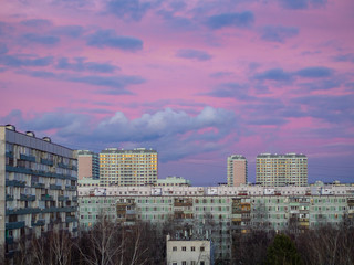 Pink sky with clouds over apartment buildings of the urban district. Panorama of the morning cityscape. Moscow city, Russia.
