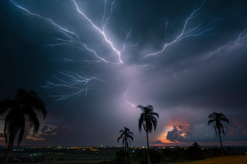 Lightning creeps across the sky during a storm shortly after the sun has set.