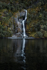 Fototapeta na wymiar Waterfall in green scenery lake - naeroyfjord in Norway