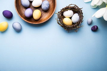 Naturally colorful dyed Easter eggs on blue background. Happy Easter holiday theme, banner