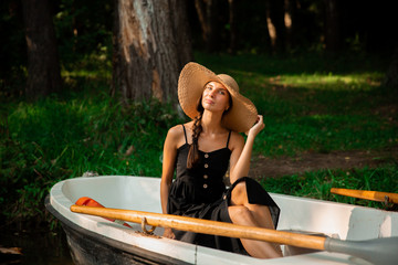 beautiful girl in a hat on a boat.summer vacation in nature.