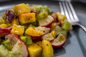 Salad with mango, cucumber and small radishes, with a dressing of mango and mint. Indian recipe.