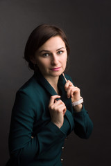 Obraz premium brunette with short hair in a green dress. Photo on a dark Studio background.
